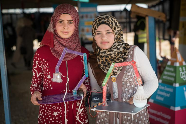 Photograph of two youth from UNICEF's Innovation Lab in Sweden, holding their inventions. 